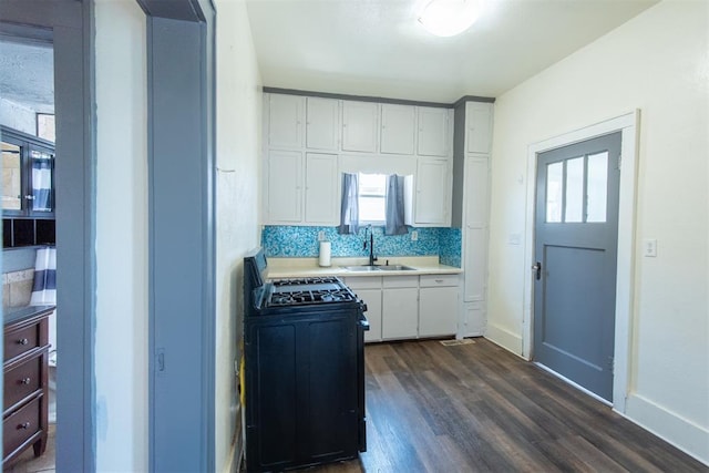 709 S Broadway, Geary, OK 73040 - kitchen with range with gas cooktop, light countertops, dark wood-style floors, white cabinetry, and a sink