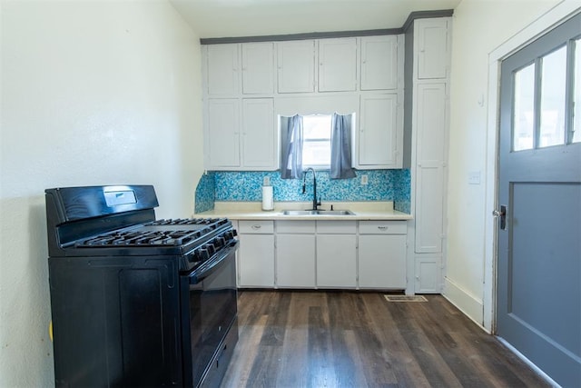 709 S Broadway, Geary, OK 73040 - kitchen with black range with gas cooktop, white cabinets, light countertops, and a sink