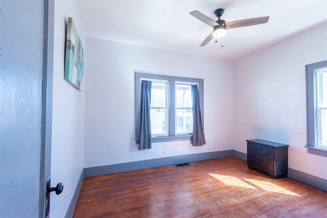 709 S Broadway, Geary, OK 73040 - unfurnished room featuring ceiling fan, wood finished floors, visible vents, and baseboards