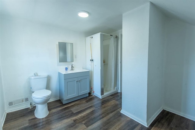 709 S Broadway, Geary, OK 73040 - full bathroom featuring visible vents, toilet, wood finished floors, a shower stall, and vanity