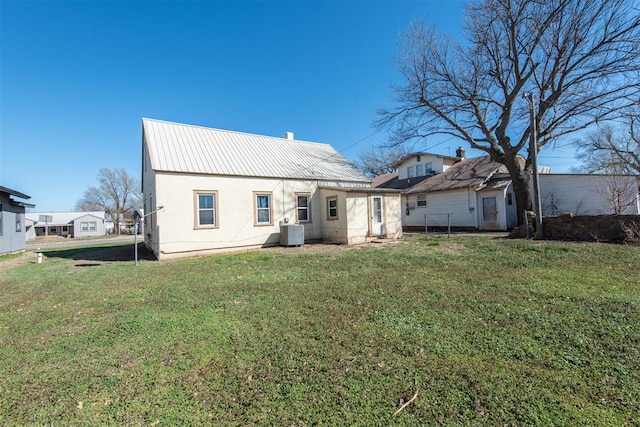 709 S Broadway, Geary, OK 73040 - rear view of property with central AC unit, a lawn, and metal roof
