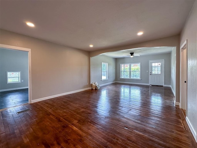 unfurnished living room featuring baseboards, visible vents, a ceiling fan, dark wood-style flooring, and recessed lighting