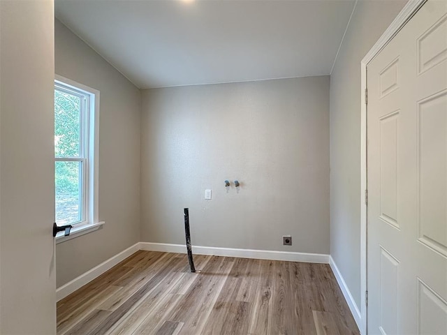 laundry area with light wood-type flooring, laundry area, plenty of natural light, and electric dryer hookup