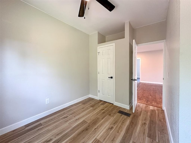 unfurnished bedroom featuring light wood-style floors, visible vents, baseboards, and ceiling fan