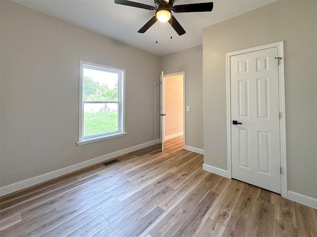 unfurnished bedroom with light wood-type flooring, visible vents, baseboards, and a ceiling fan