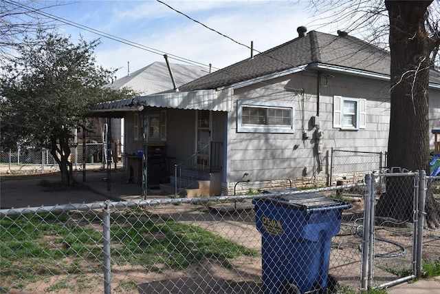 201 N Williams Ave, El Reno, OK 73036 - view of home's exterior with a gate, roof with shingles, and central air condition unit