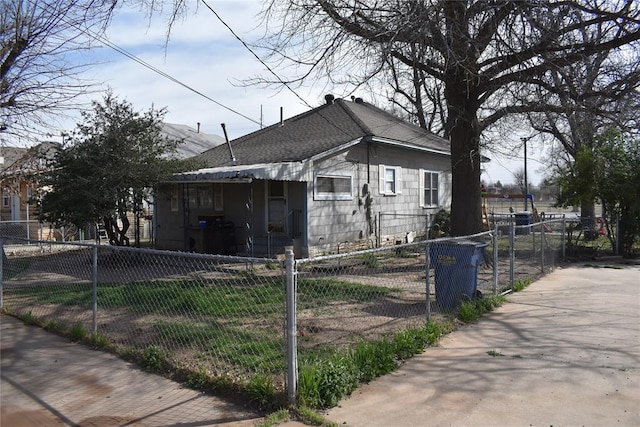 201 N Williams Ave, El Reno, OK 73036 - view of home's exterior with a fenced front yard, roof with shingles, and a gate