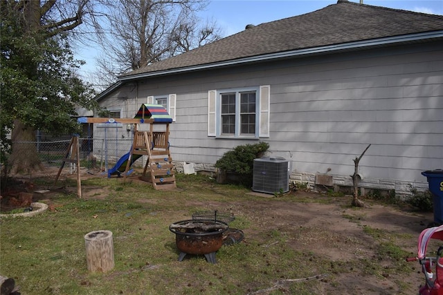 201 N Williams Ave, El Reno, OK 73036 - back of property with a playground, central AC, an outdoor fire pit, and a shingled roof