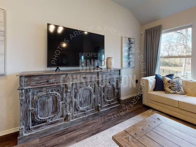 living room with vaulted ceiling, baseboards, and wood finished floors