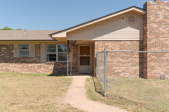 view of front of property with brick siding, roof with shingles, and a front yard