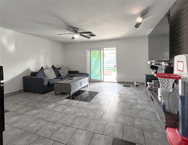 living room with tile patterned flooring, visible vents, baseboards, and ceiling fan