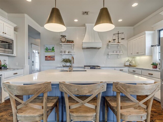 39 Boulevard, Carlton Landing, OK 74432 - kitchen featuring stainless steel microwave, premium range hood, white cabinetry, open shelves, and a sink