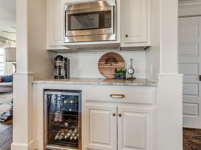 39 Boulevard, Carlton Landing, OK 74432 - bar featuring wine cooler, stainless steel microwave, and decorative backsplash