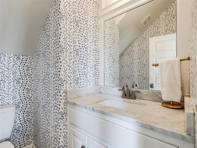 39 Boulevard, Carlton Landing, OK 74432 - half bathroom featuring lofted ceiling, visible vents, vanity, and toilet