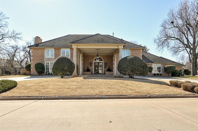 view of front of home with a chimney and concrete driveway