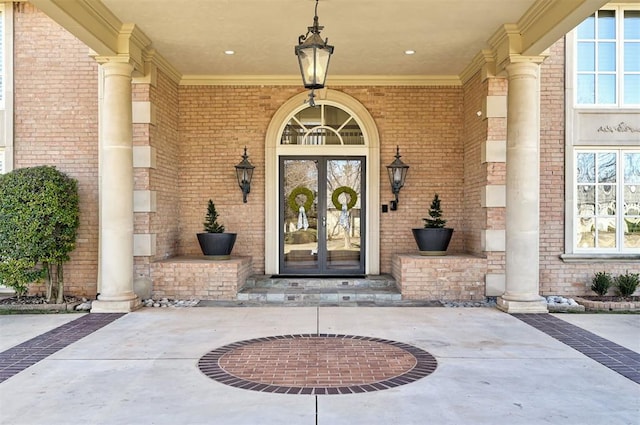 property entrance featuring french doors and brick siding