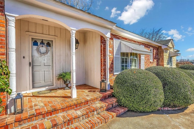 view of exterior entry featuring brick siding