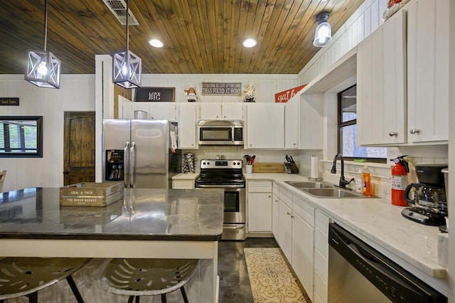 kitchen featuring wooden ceiling, white cabinets, appliances with stainless steel finishes, and a sink