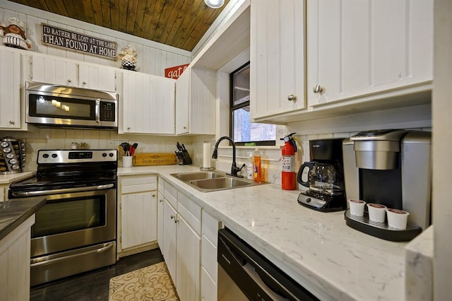 kitchen featuring a sink, tasteful backsplash, appliances with stainless steel finishes, and white cabinets