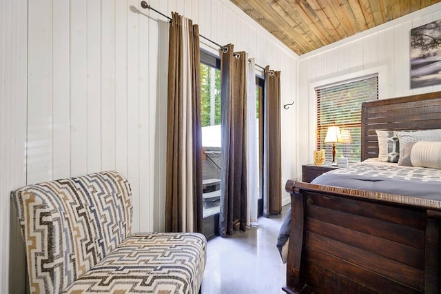 bedroom featuring finished concrete floors, wood walls, and wooden ceiling