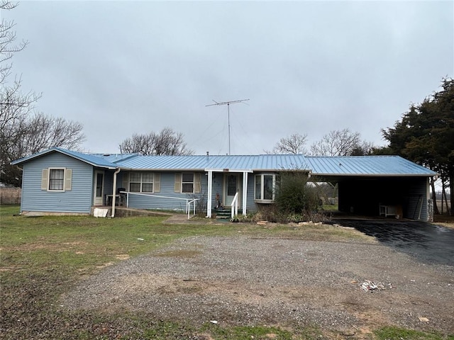 single story home featuring aphalt driveway, metal roof, a carport, and a front lawn