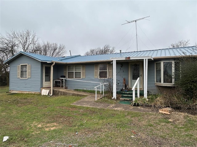 ranch-style home featuring metal roof and a front yard