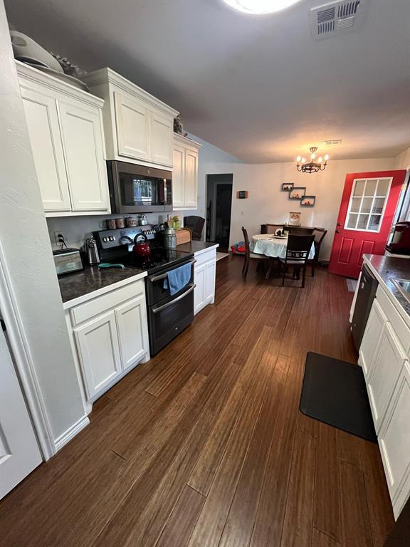 kitchen with visible vents, white cabinets, stainless steel microwave, dark wood-style flooring, and double oven range