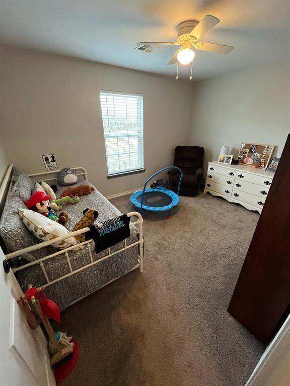 recreation room featuring a ceiling fan, carpet, visible vents, and baseboards