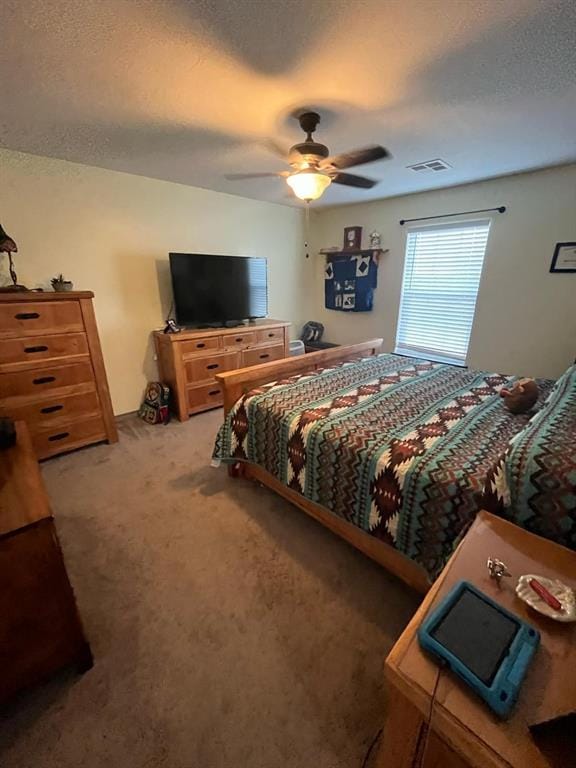 bedroom featuring a textured ceiling, carpet floors, ceiling fan, and visible vents