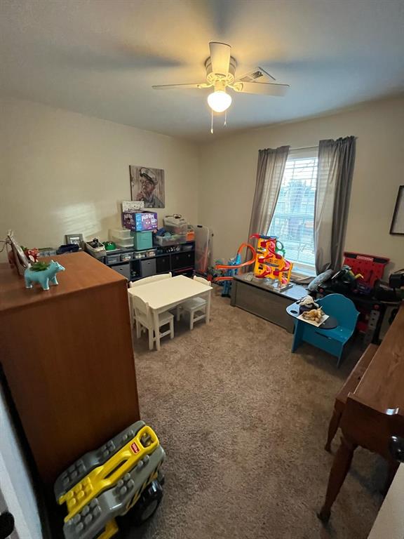 game room featuring a ceiling fan and carpet