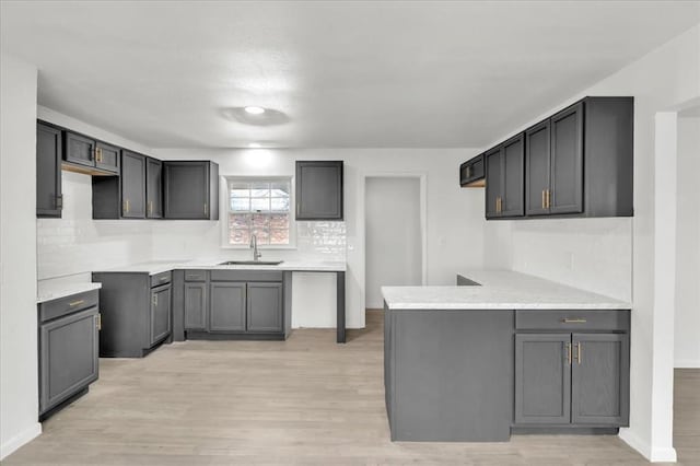 10313 N Mckinley Ave, Oklahoma City, OK 73114 - kitchen featuring tasteful backsplash, light wood-style floors, a sink, and a peninsula