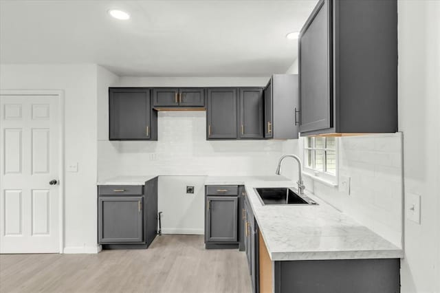 10313 N Mckinley Ave, Oklahoma City, OK 73114 - kitchen with gray cabinetry, decorative backsplash, a sink, and light wood-style floors