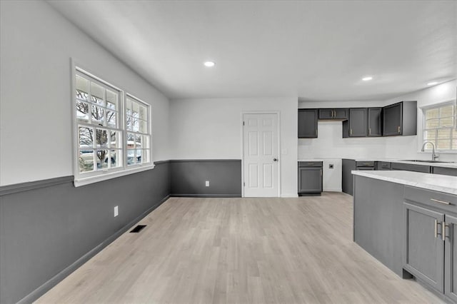 10313 N Mckinley Ave, Oklahoma City, OK 73114 - kitchen with light countertops, visible vents, recessed lighting, a sink, and light wood-type flooring
