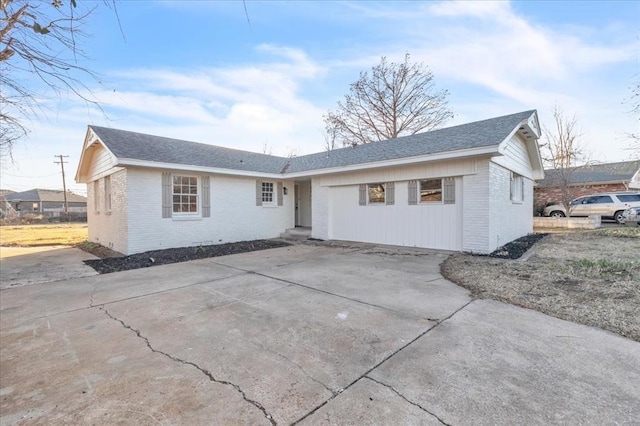10313 N Mckinley Ave, Oklahoma City, OK 73114 - view of front of home featuring roof with shingles, brick siding, and concrete driveway