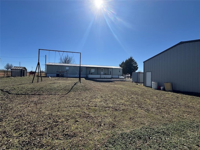 view of yard featuring an outbuilding, a pole building, and fence