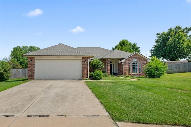 ranch-style home with a garage, concrete driveway, fence, a front lawn, and brick siding