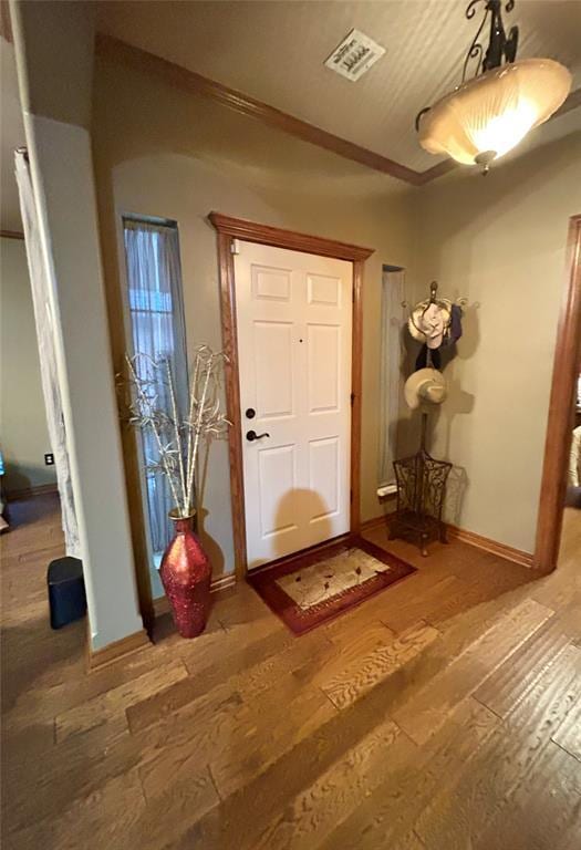 foyer with visible vents, baseboards, and hardwood / wood-style flooring