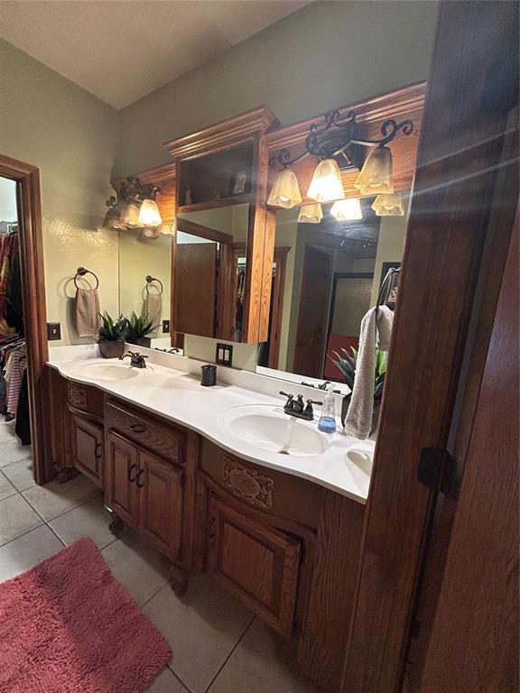 bathroom with a sink, double vanity, and tile patterned floors