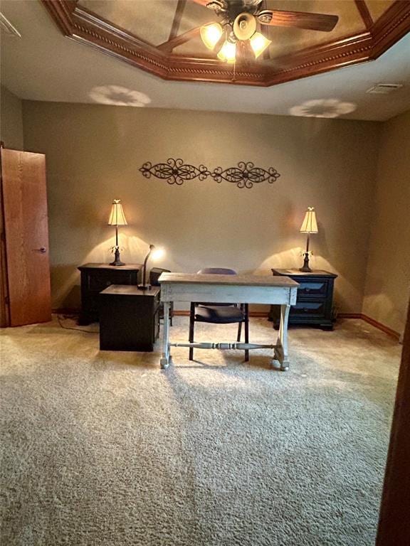 office space featuring visible vents, ceiling fan, baseboards, a tray ceiling, and carpet floors