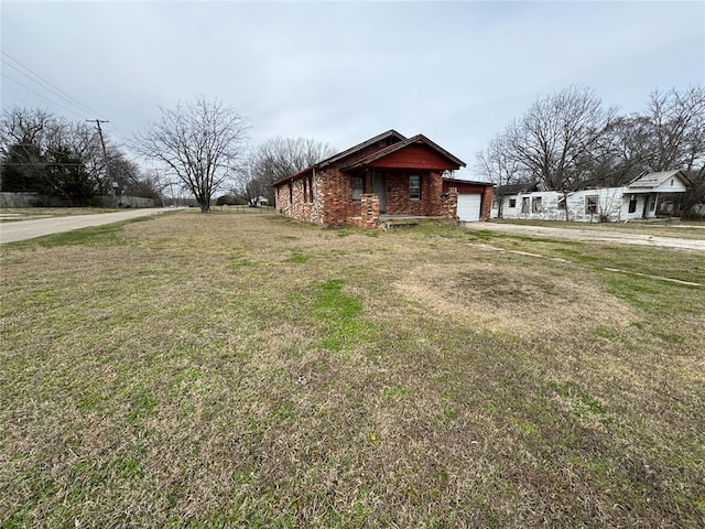 view of property exterior with brick siding, a yard, driveway, and an attached garage