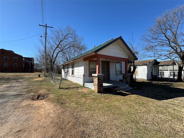 shotgun-style home with a porch and a front yard