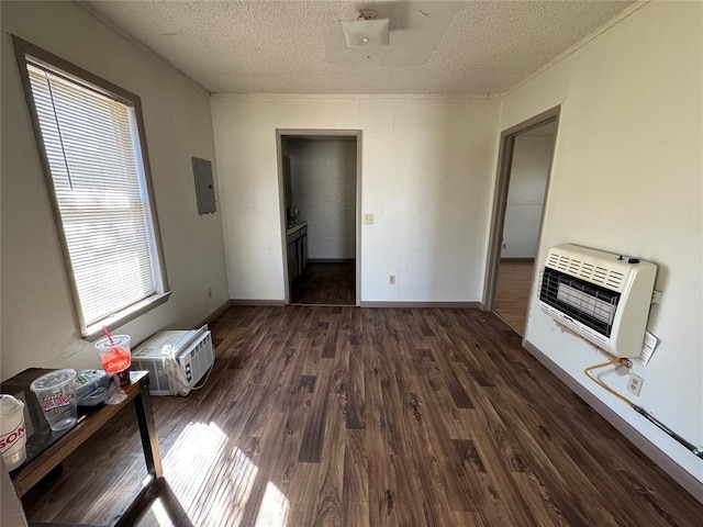 unfurnished bedroom with a textured ceiling, dark wood-style flooring, electric panel, and heating unit
