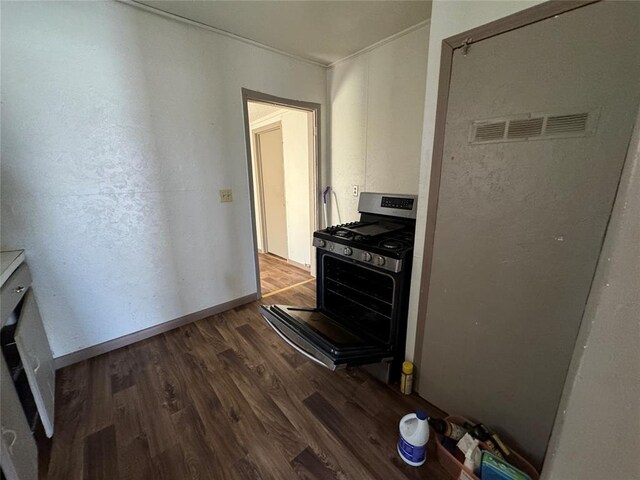 kitchen with stainless steel gas stove, baseboards, and wood finished floors