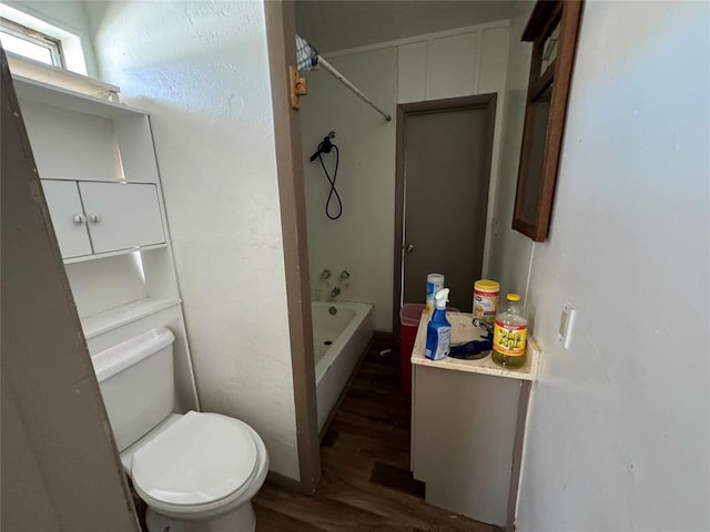 bathroom with shower / bathtub combination, wood finished floors, and toilet