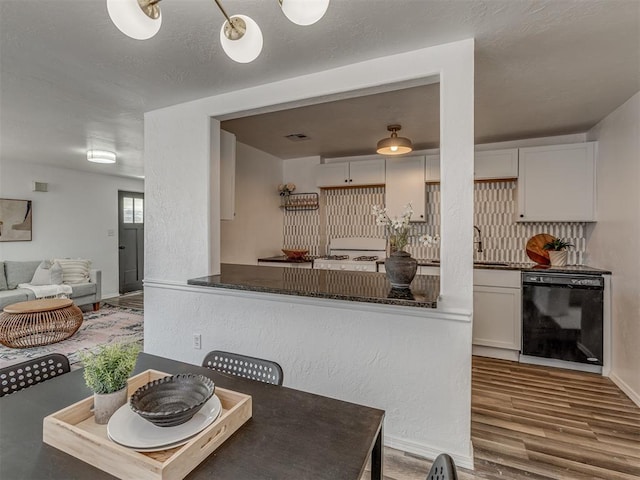 dining room with wood finished floors, visible vents, and baseboards