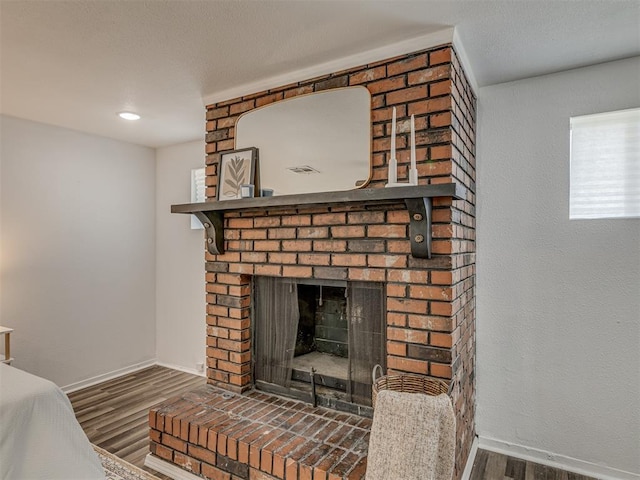 room details with a brick fireplace, baseboards, and wood finished floors