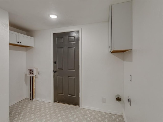 washroom with light floors, cabinet space, and baseboards