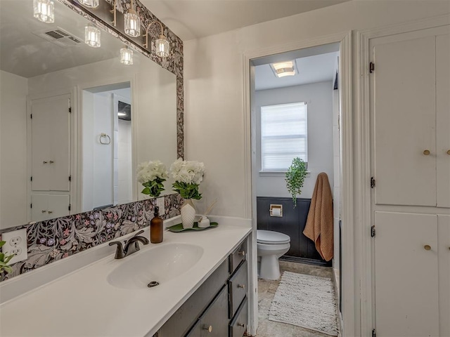 bathroom featuring toilet, visible vents, and vanity