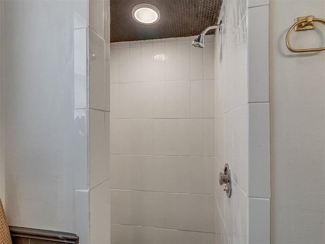 interior details featuring a tile shower