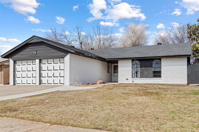 view of front of property featuring a garage, a front lawn, concrete driveway, and brick siding